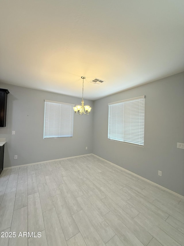1241 E Palo Verde Dr, Casa Grande, AZ 85122 - spare room featuring a chandelier, light wood-style flooring, and baseboards