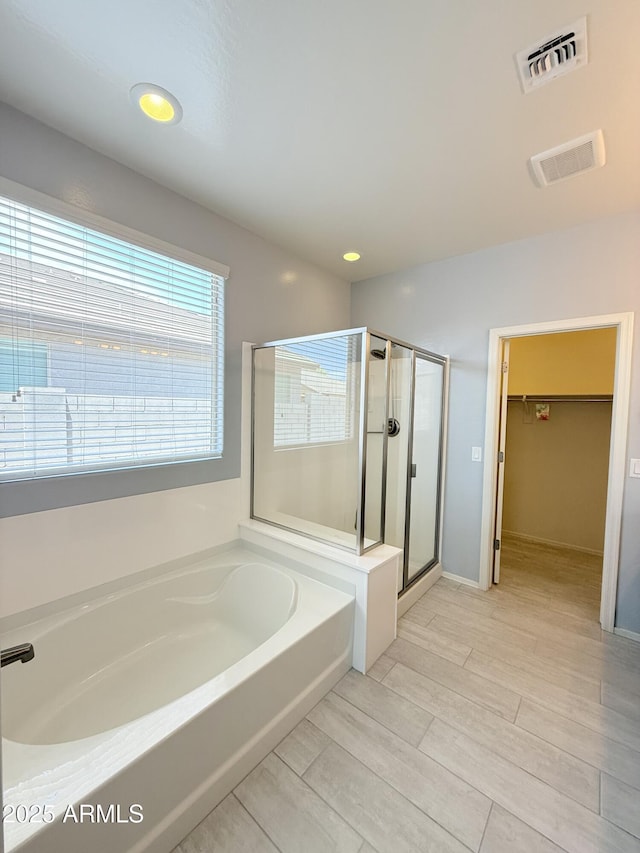 1241 E Palo Verde Dr, Casa Grande, AZ 85122 - bathroom featuring a bath, a shower stall, a spacious closet, and wood finished floors