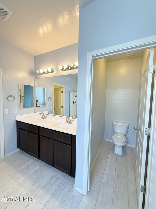 1241 E Palo Verde Dr, Casa Grande, AZ 85122 - full bathroom featuring wood tiled floors, double vanity, toilet, and baseboards