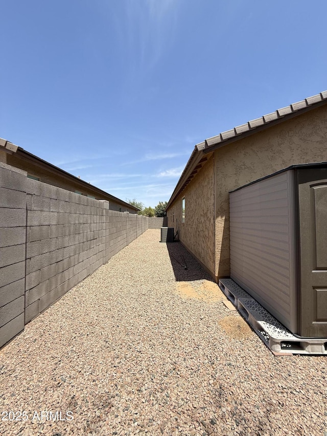 1241 E Palo Verde Dr, Casa Grande, AZ 85122 - view of side of home with a fenced backyard, stucco siding, and central air condition unit
