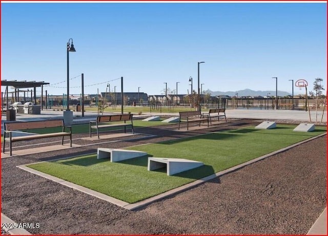 view of home's community with a mountain view and a yard