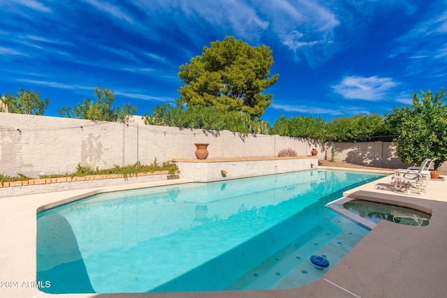 view of pool featuring a patio and an in ground hot tub