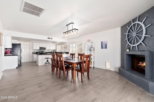 dining area with light wood-type flooring and a premium fireplace