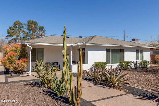 single story home featuring roof with shingles and stucco siding