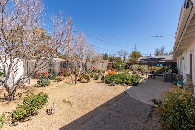 view of yard with a patio area, central AC, and a fenced backyard