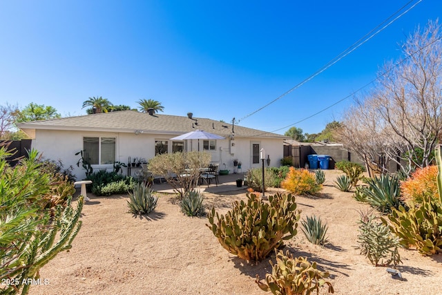 back of property with stucco siding, a patio area, and fence