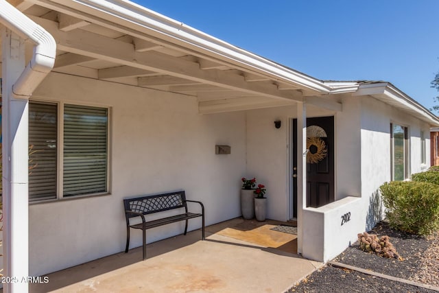doorway to property featuring stucco siding