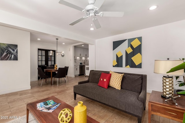 living area with a ceiling fan, recessed lighting, light wood-style floors, and baseboards