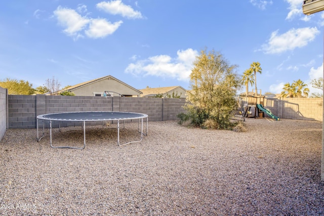 view of yard with a playground and a trampoline