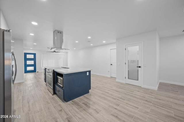 kitchen with a center island, blue cabinets, ceiling fan, appliances with stainless steel finishes, and extractor fan