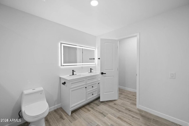 bathroom featuring vanity, hardwood / wood-style flooring, and toilet