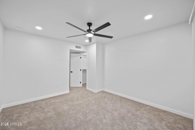 spare room with ceiling fan and light carpet