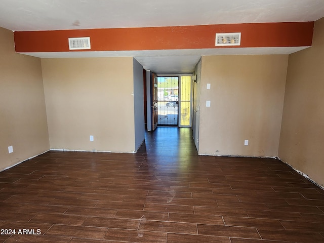 unfurnished room with dark hardwood / wood-style flooring and a wall of windows