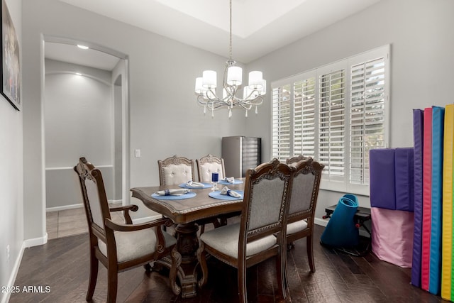 dining space with an inviting chandelier and dark hardwood / wood-style floors