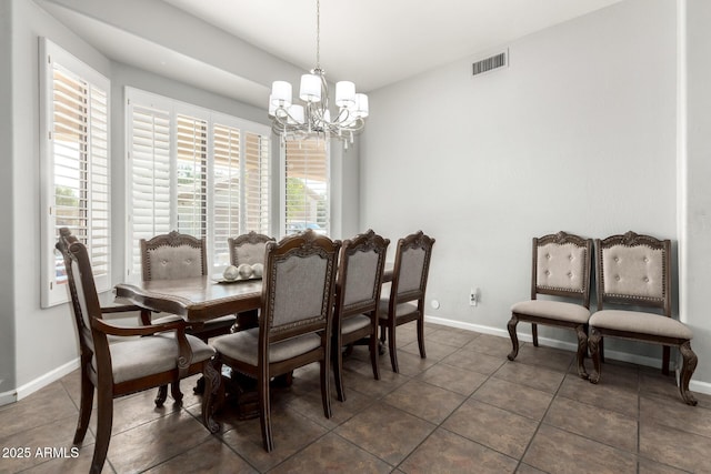 tiled dining area featuring a chandelier