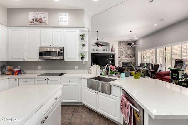 kitchen with a fireplace, sink, white cabinets, ceiling fan, and stainless steel appliances