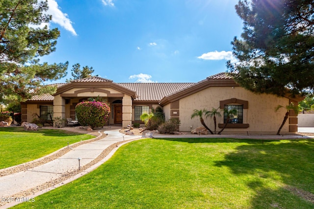 mediterranean / spanish home featuring a front yard