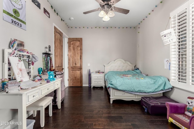 bedroom with multiple windows and dark hardwood / wood-style floors