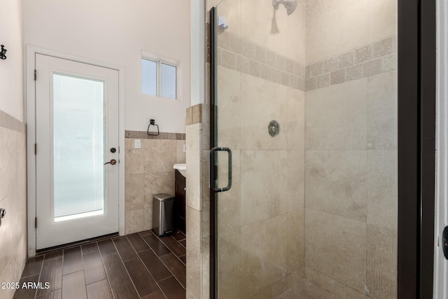 bathroom featuring an enclosed shower and tile walls