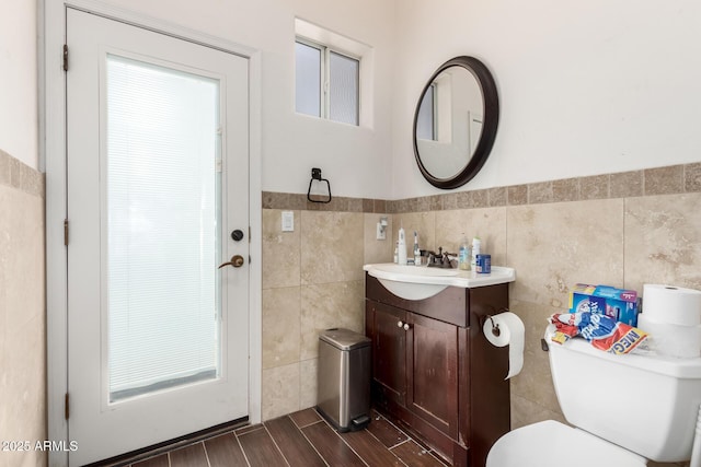 bathroom featuring vanity, tile walls, and toilet