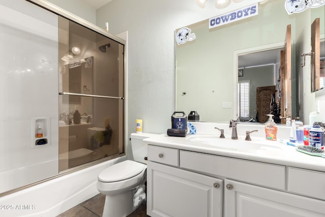 full bathroom featuring tile patterned flooring, vanity, combined bath / shower with glass door, and toilet