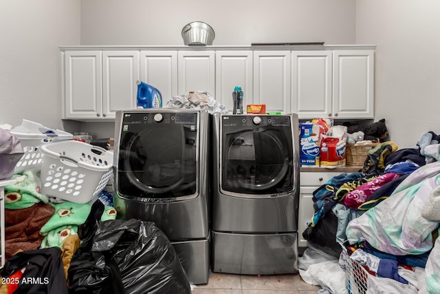 laundry area with cabinets, independent washer and dryer, and light tile patterned flooring