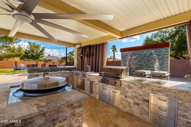 view of patio / terrace with area for grilling, ceiling fan, and exterior kitchen