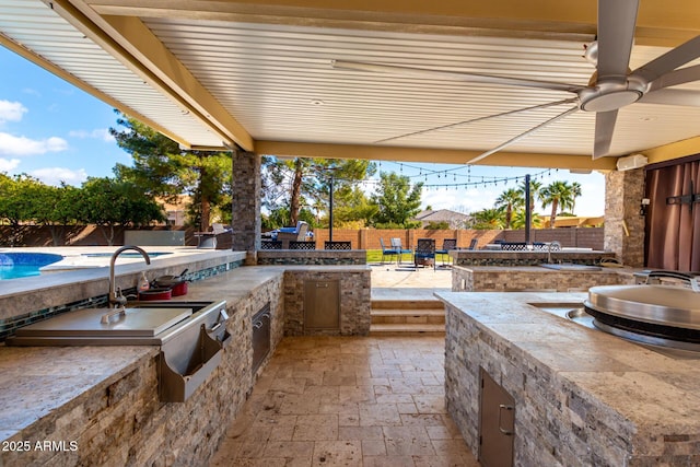 view of patio / terrace featuring ceiling fan and exterior kitchen