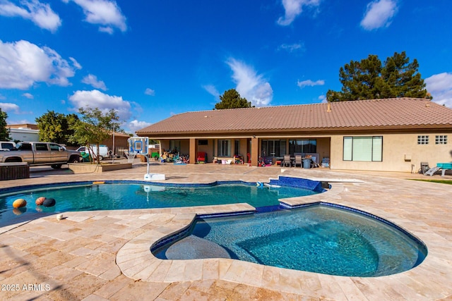 view of swimming pool featuring a patio and an in ground hot tub