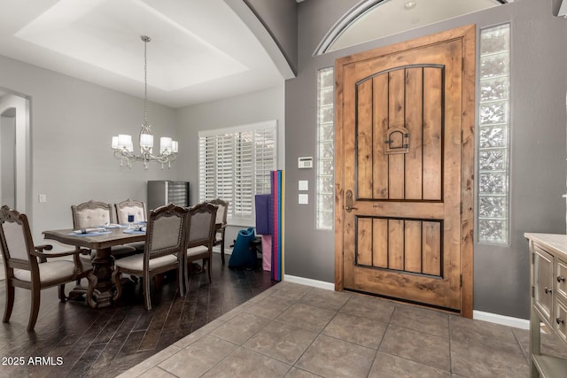 entryway with a chandelier and dark tile patterned floors