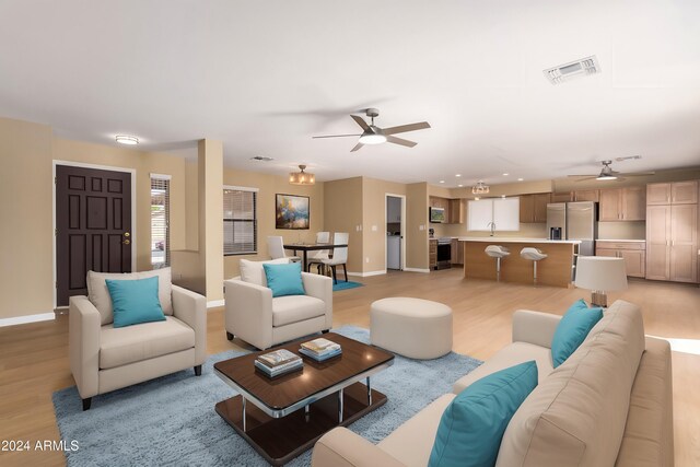 living room featuring light hardwood / wood-style floors, sink, and ceiling fan