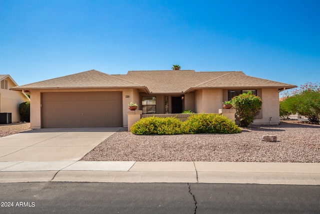 view of front of home with central AC unit and a garage