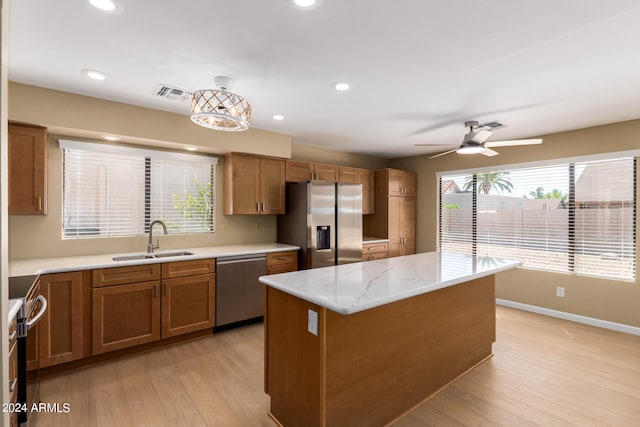 kitchen featuring a healthy amount of sunlight, sink, appliances with stainless steel finishes, and a center island