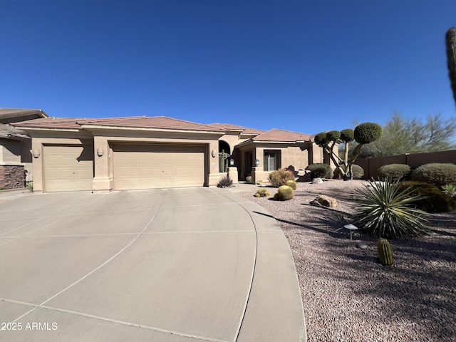 view of front of home featuring a tiled roof, stucco siding, driveway, and a garage