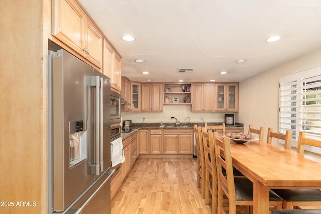 1445 W Wood Dr, Phoenix, AZ 85029 - kitchen with stainless steel appliances, light wood-style floors, recessed lighting, glass insert cabinets, and dark countertops