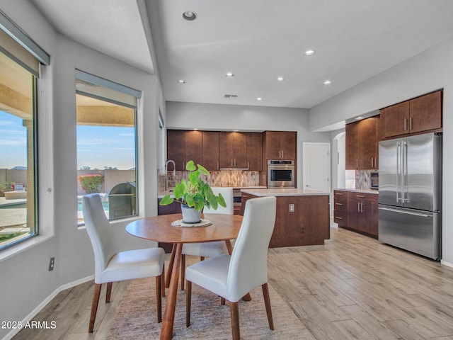 dining space with sink and light hardwood / wood-style floors