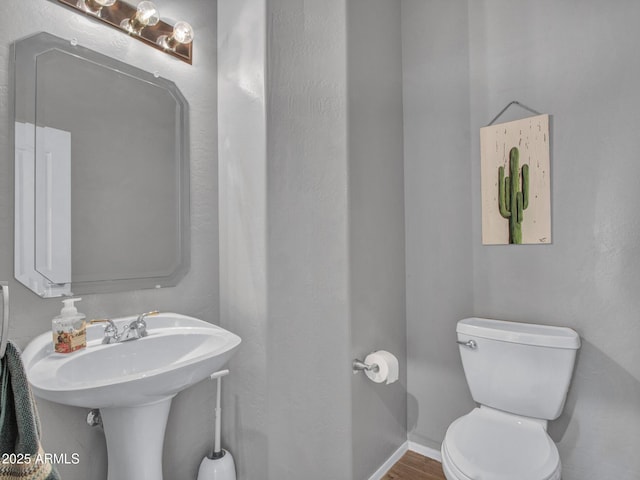 bathroom with toilet and hardwood / wood-style floors