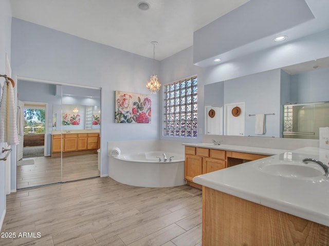 bathroom featuring hardwood / wood-style flooring, vanity, a tub, and a wealth of natural light