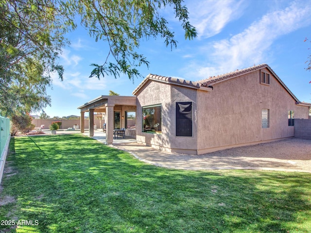 back of property with a yard and a patio