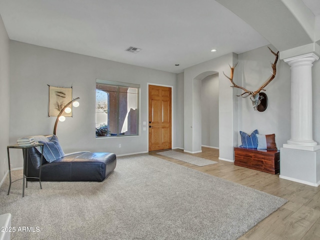 sitting room featuring light hardwood / wood-style floors and decorative columns