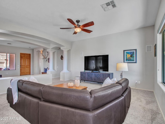 living room with decorative columns, light carpet, and ceiling fan