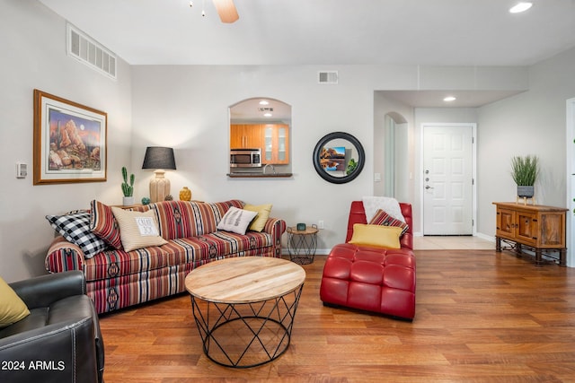 living room featuring light wood-type flooring and ceiling fan