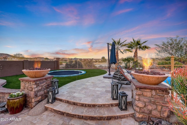 patio terrace at dusk featuring a fire pit