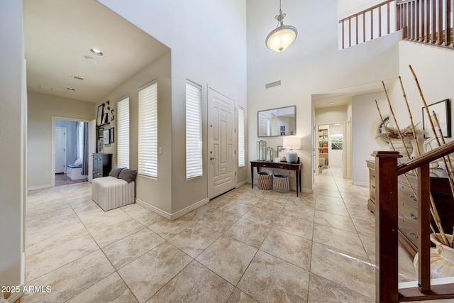 foyer with light tile patterned flooring and a high ceiling