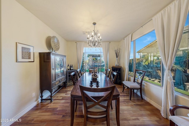 dining room featuring an inviting chandelier and dark wood-type flooring