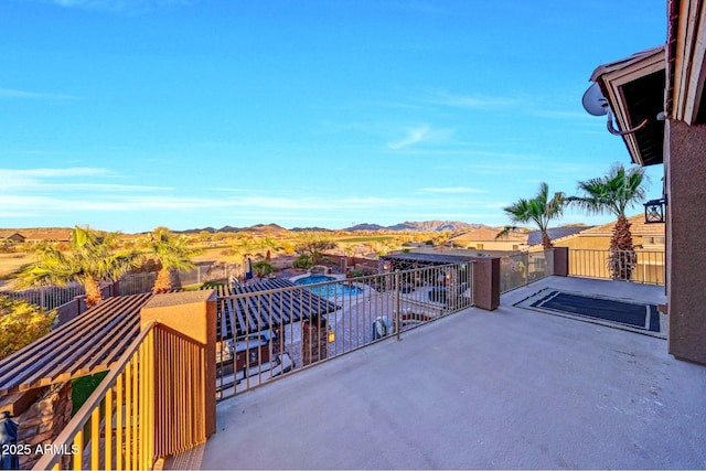 view of patio with a balcony and a mountain view