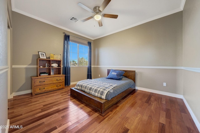 bedroom with ornamental molding, hardwood / wood-style floors, and ceiling fan