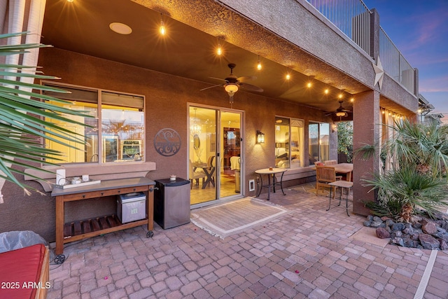 patio terrace at dusk featuring ceiling fan