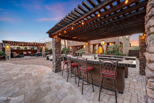 patio terrace at dusk with a pergola and exterior bar