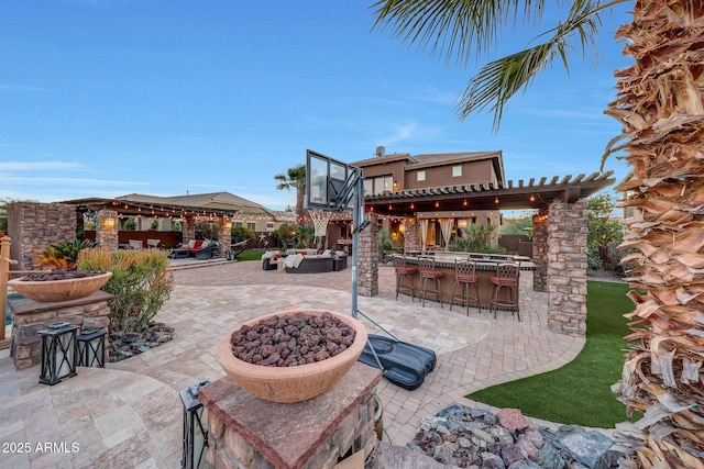 view of patio featuring a bar, a gazebo, and an outdoor living space with a fire pit